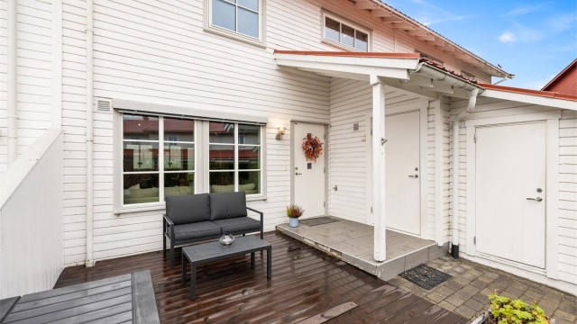 Den overbygde inngangen og terrassen på forsiden skaper en hyggelig velkomst.