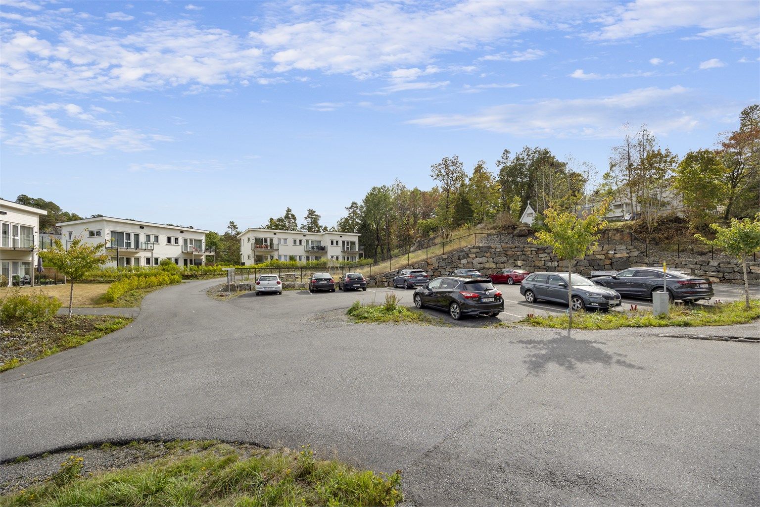 Felles parkeringsplass med en plass til hver leilighet + gjesteplasser. Det er lagt trekkerør klart til alle parkeringsplassene, ved behov for elbillader.