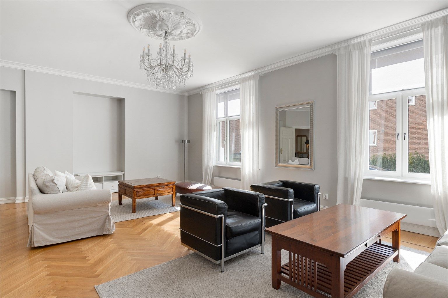 Stor og luftig stue med høyt under taket, store vindusflater, samt flott takrosett med lysekrone. 