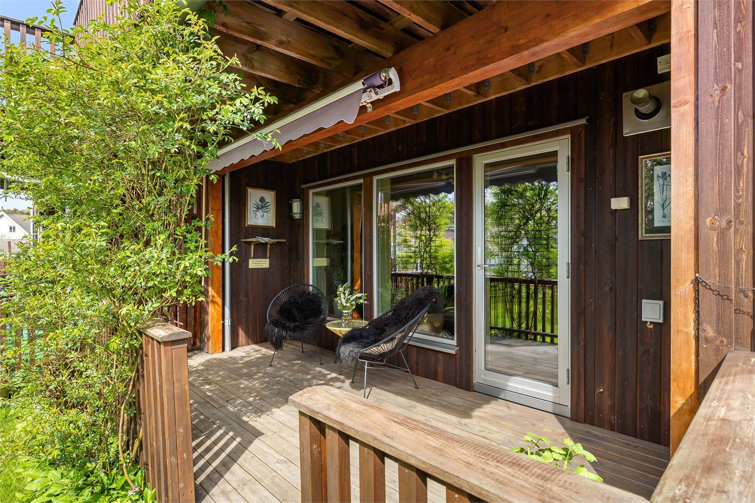 På terrassen sitter du henvendt mot solens gang på ettermiddag og kveld, naturlig skjermet av vakre rosebusker.