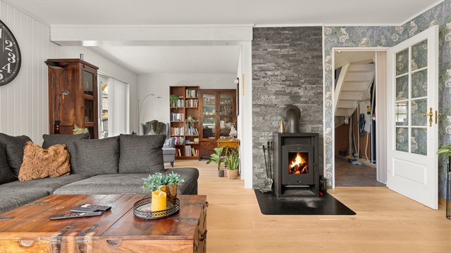 Stuen er utstyrt med en peisovn som gir ekstra varme og hygge.