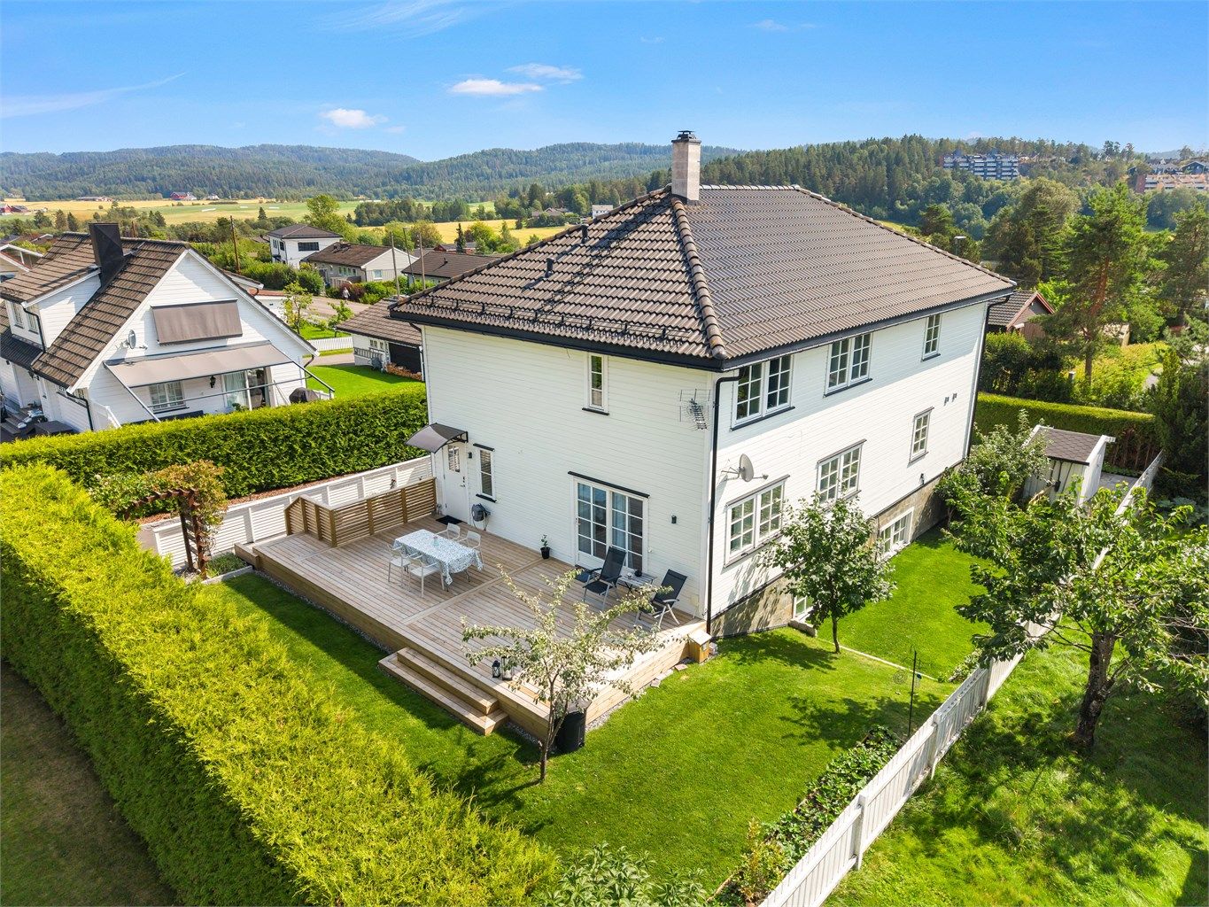Eiendommen er omkranset av en formklippet hekk som gir eiendommen et eksklusivt preg og samtidig skjermer mot innsyn.
