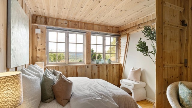 Et lunt og tilbaketrukket soverom med parkett på gulv og trepregede overflater