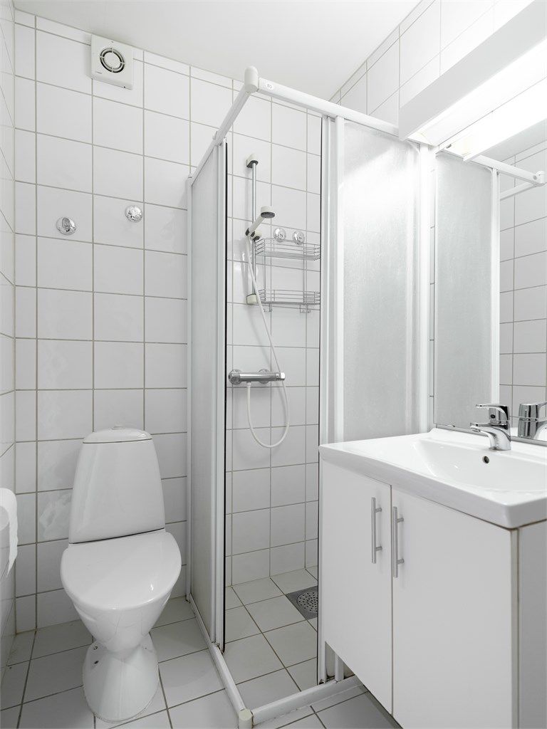 Badet er innredet med servantskap med speil og lys, dusjhjørne og toalett. Vifte.