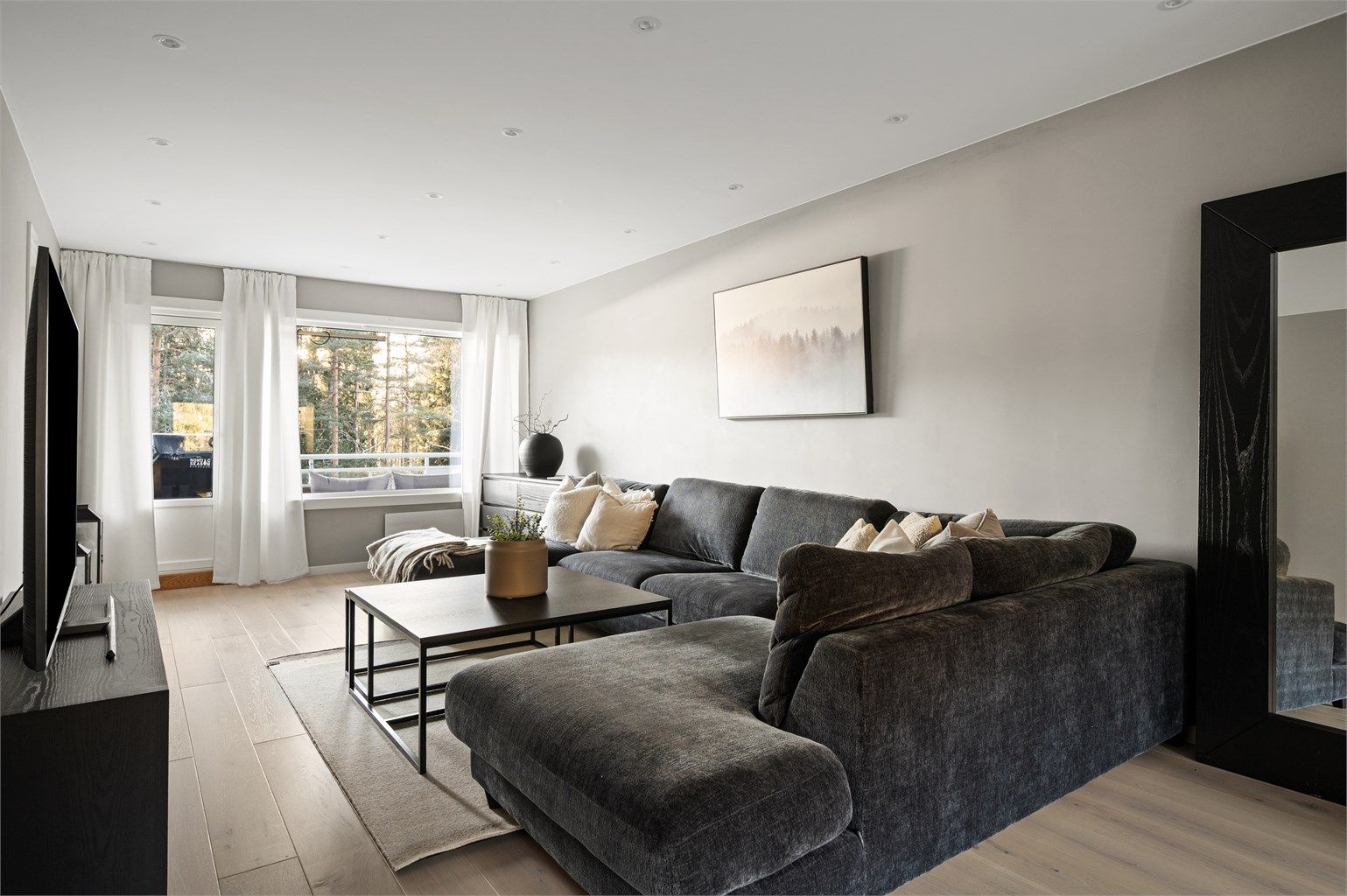 Store vindusflater på begge sider av leiligheten sørger for rikelig med naturlig lys.