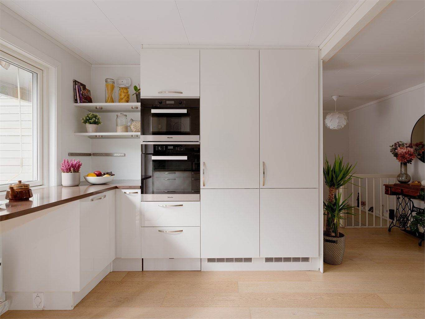 Kjøkkenet fra HTH er moderne og tidløst. Løsningen utnytter plassen optimalt med takhøye skap og generøs benkeflate - perfekt både for den dedikerte hobbykokken og for dem som setter pris på et sosialt og funksjonelt kjøkkenmiljø. 