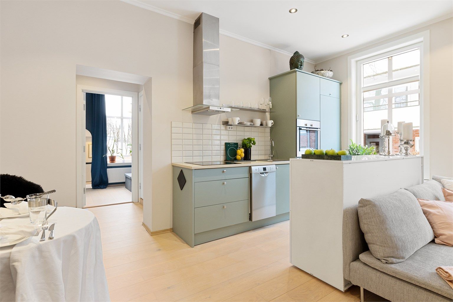 Den åpne løsningen mellom stue og kjøkken skaper en sosial og innbydende atmosfære.