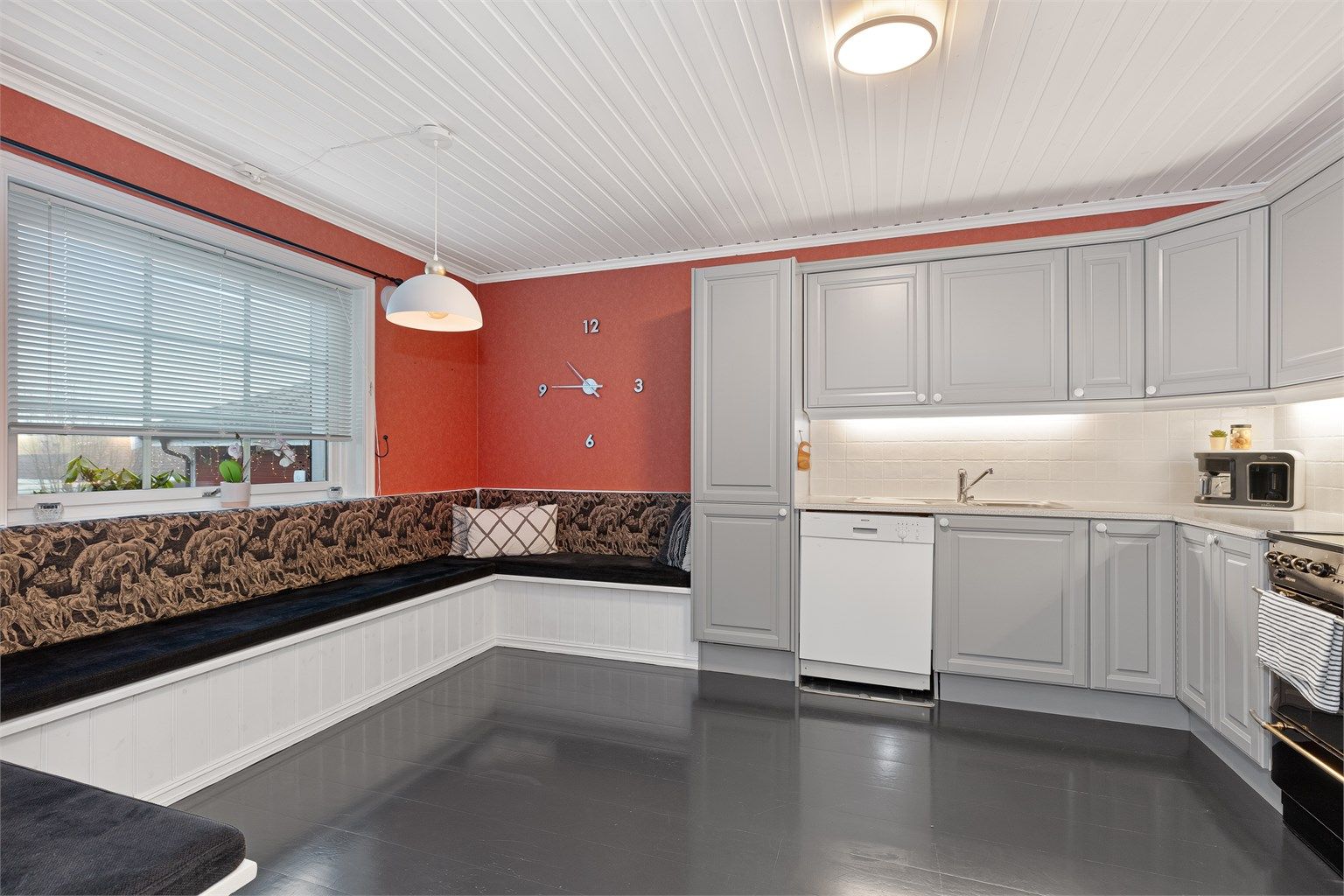 En stor, plassbygget sittebenk fungerer som en sosial spiseplass for hele familien. Her er det god plass til stort spisebord for familien