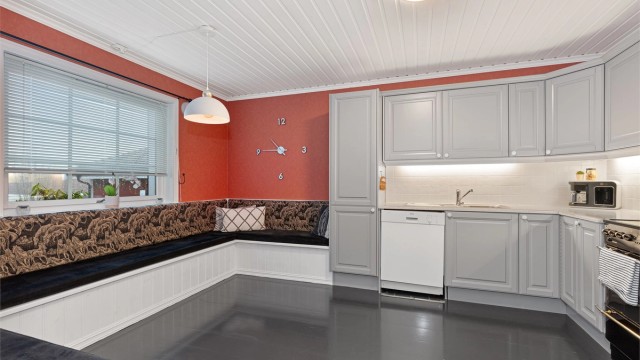 En stor, plassbygget sittebenk fungerer som en sosial spiseplass for hele familien. Her er det god plass til stort spisebord for familien