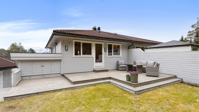 Flott terrasse på 38 m² har utgang fra kjøkkenet og er omkranset av en levegg.