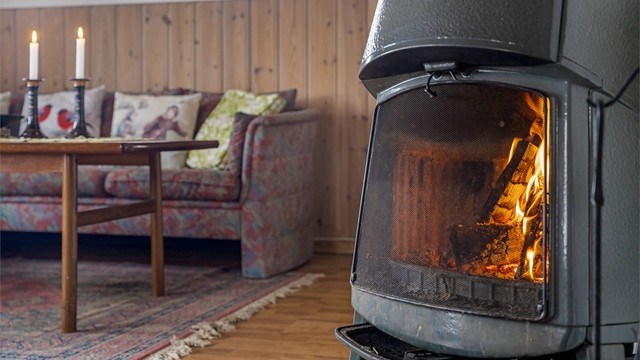 Vedovnen er av eldre årgang, men likevel atmosfærefremmende i stuen. Hytta varmes ellers opp med hjelp av elektrisitet.