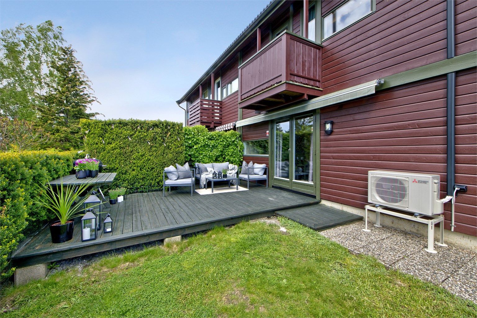 Pent opparbeidet uteplass med platting og flat hage - markise