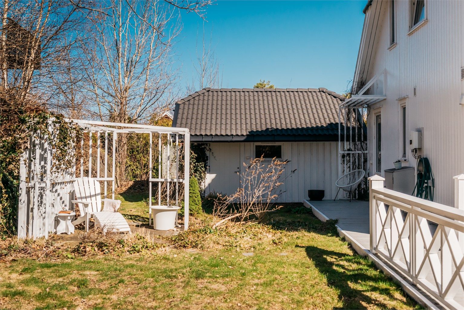 Hagen er pent opparbeidet med plen, busker og trær.