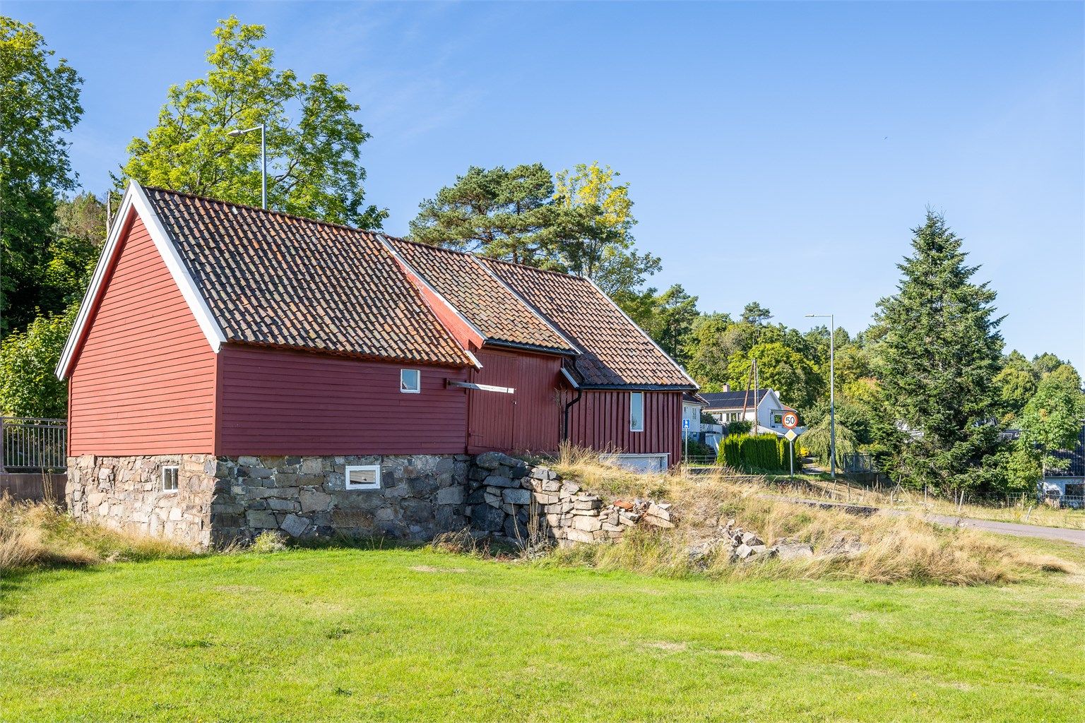 Klassisk låve fra slutten av 1800-tallet oppført i tradisjonelt treverk over natursteinsmur.
