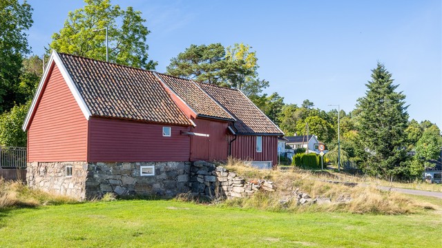 Klassisk låve fra slutten av 1800-tallet oppført i tradisjonelt treverk over natursteinsmur.