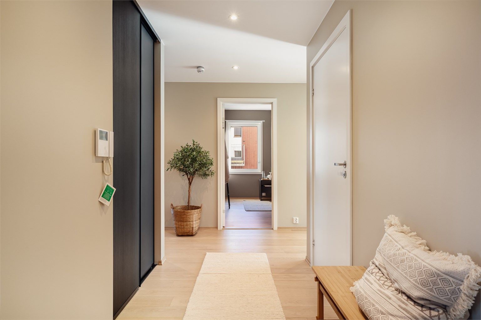 Den romslige entreen er et representativt første møte med leiligheten. Entreen kan lukkes av mot stuen for å skjerme soverommene mot lyd fra den sosiale sonen.