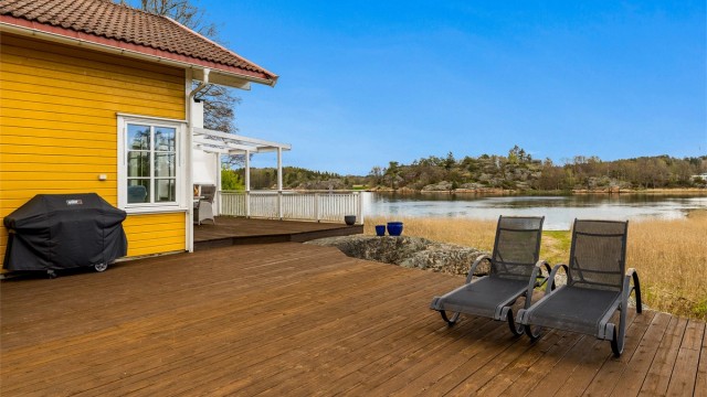 Hytta har en stor flott terrasse med nydelig utsikt til sjøen.