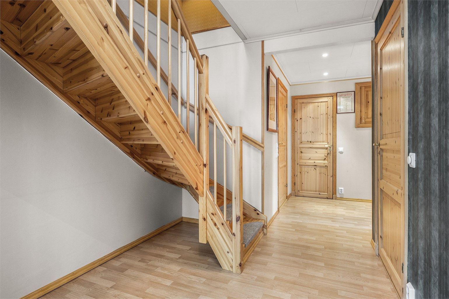 Praktisk gangareal med god plass til oppbevaring og en naturlig forbindelse mellom etasjene.