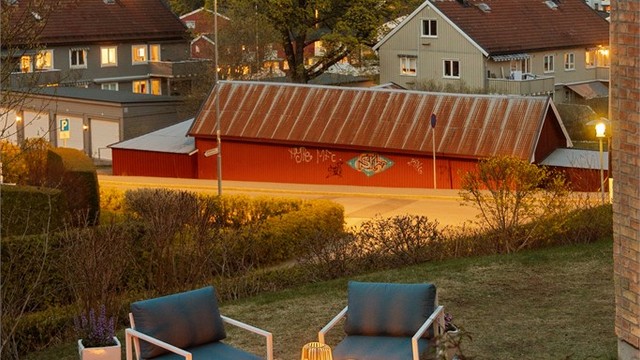 Plenen rundt terrassen strekkes seg rundt hjørnet av boligen og byr på en skjermet, hellelagt uteplass