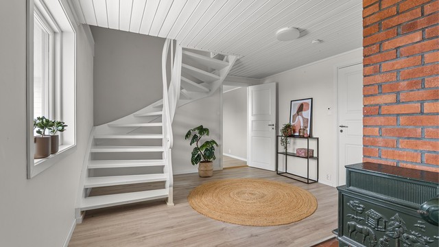 En romslig hall er meget praktisk når familien skal ut eller kommer hjem samtidig. Her er det i tillegg ildsted.