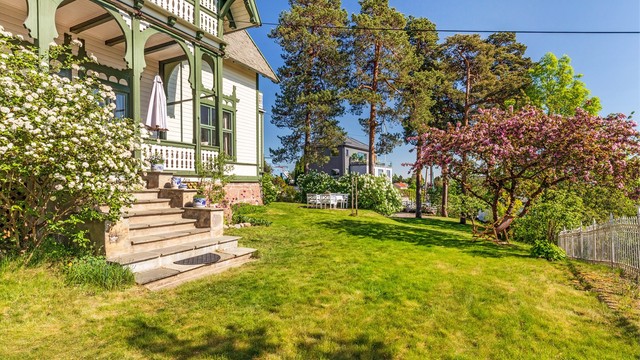 En trapp i naturstein leder fra verandaen og ned til hagen