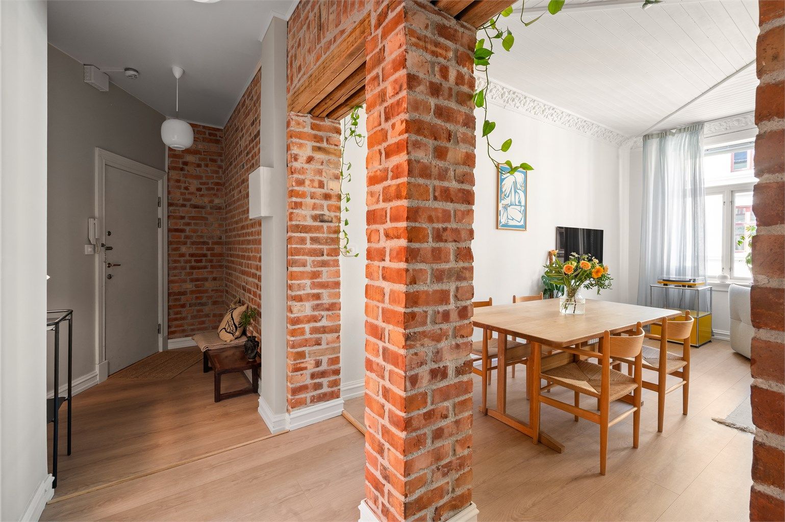 En åpen passasje er etablert mellom gangen og stuen, noe som gir en moderne romflyt.