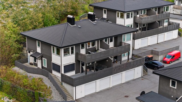 Bygningen har valmtak belagt med takstein og liggende trekledning på fasadene.
