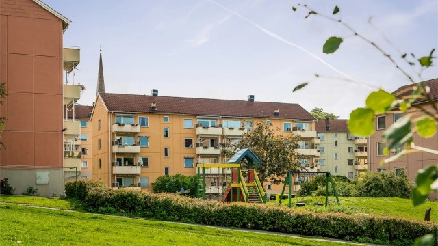 På forsiden av blokken er det satt ut sittegruppe som innbyr til grilling, mens barna sparkesykler eller hopper paradis