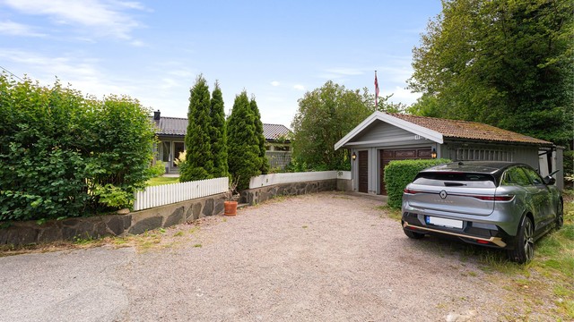 Tilhørende garasje og tomten grenser mot friområde.