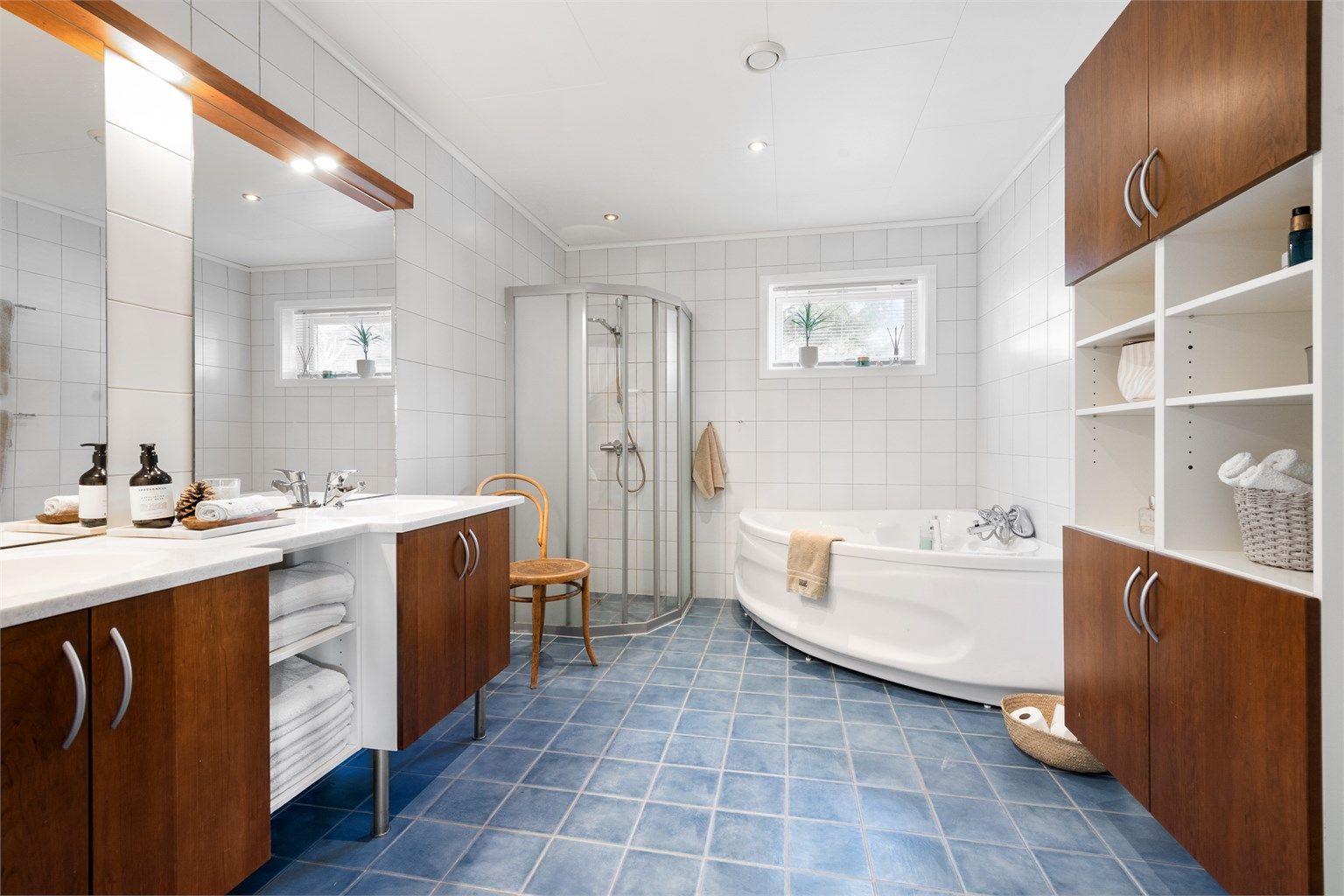 Det romslige badet i underetasjen har både hjørnebadekar og dusjhørne, samt stor og romslig baderomsinnredning