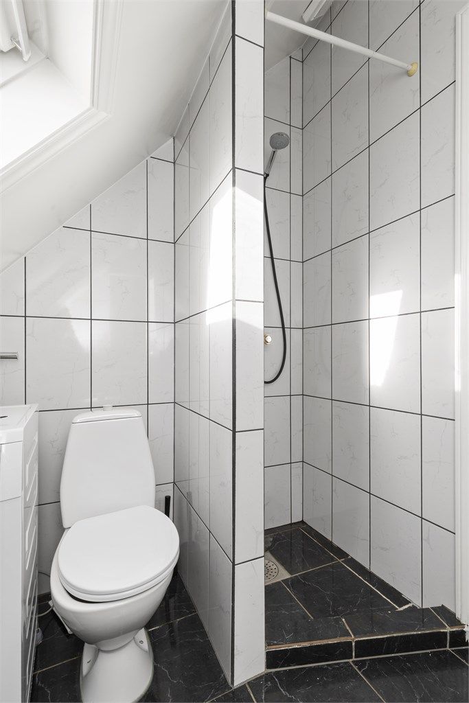 Badet har separat dusjhjørne og toalett plassert under skråtaket.