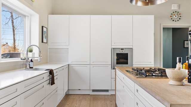 Integrerte hvitevarer: Nedfelt gassplatetopp i kjøkkenøy, stekeovn, oppvaskmaskin og kjøleskap. Ventilator fra himling med kullfilter. Kjøkkenøy har benkeplate i heltre eik.