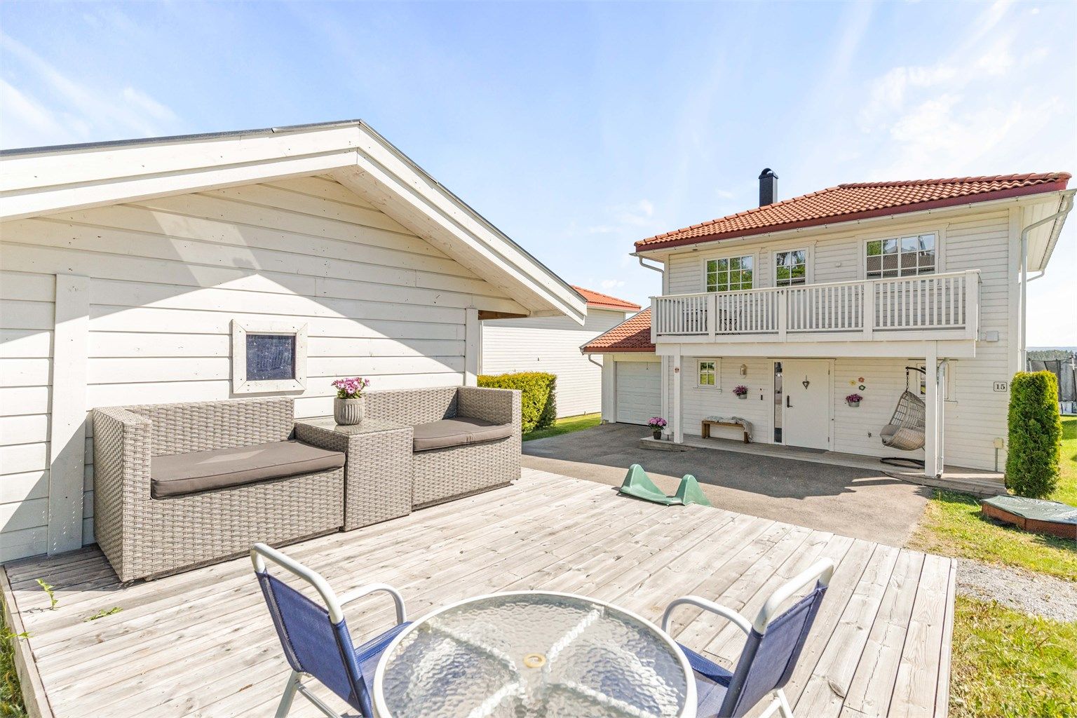 Ved inngangspartiet er det en terrasse belagt med terrassebord.