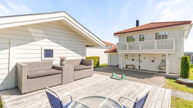 Ved inngangspartiet er det en terrasse belagt med terrassebord.