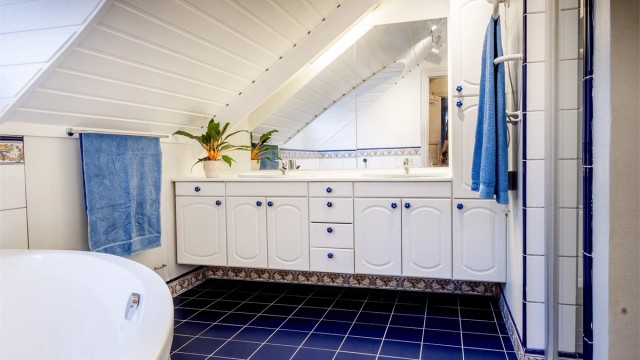Badet er fra byggeåret og gitt TG 3 på bakgrunn av alder, men funksjonelt og noe påkostet i nyere tid. To servanter muliggjør samtidig bruk av to personer.