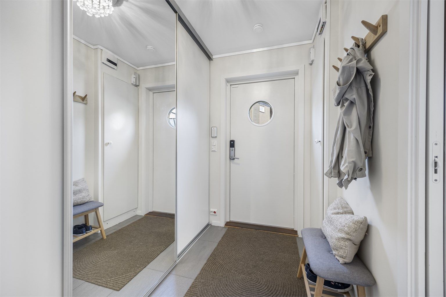 Entréen har flislagt gulv med varmekabler og god oppbevaringsplass i skyvedørsgarderobe.