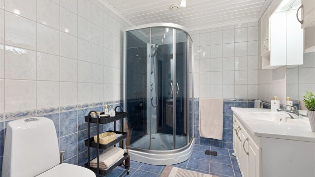 Badet er videre utstyrt med dusjkabinett og toalett.