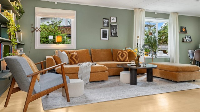 Stuen har store vindusflater som slipper inn rikelig med naturlig lys og god plass til en romslig sofagruppe.