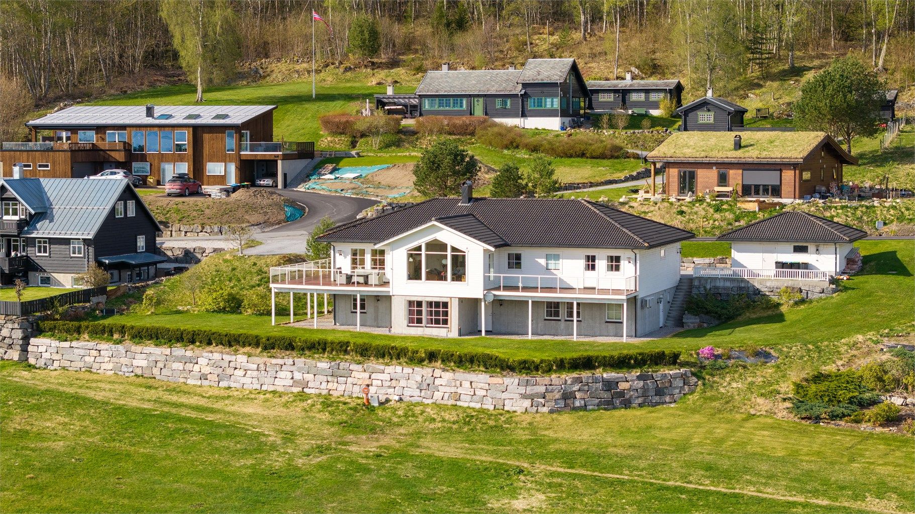 Eneboligen ligger på en romslig tomt på 1,6 mål med store, åpne plenarealer.