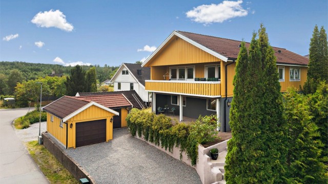 Den frittstående garasjen har bod i bakkant.