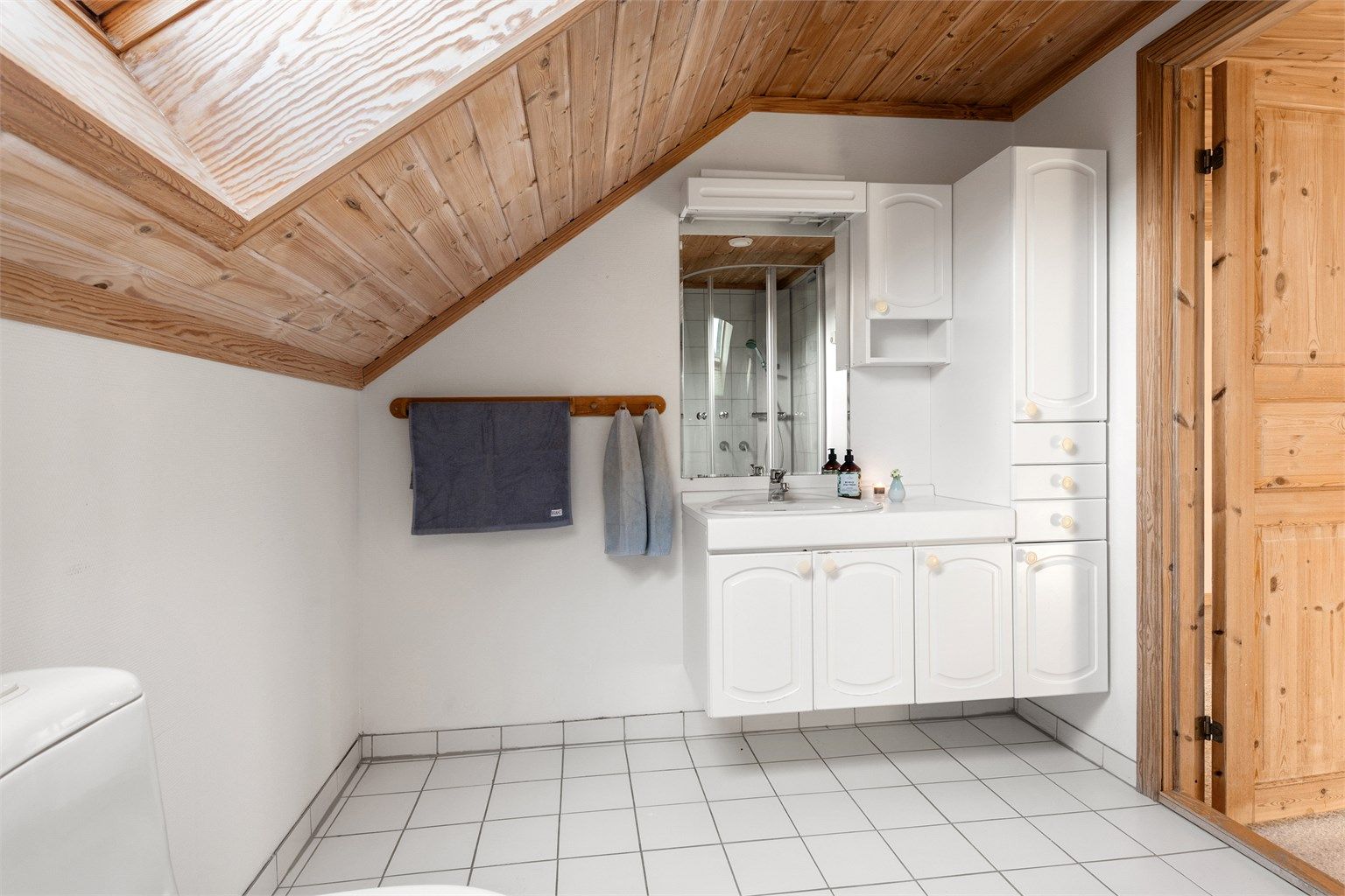 Bad i 2. etasje med flislagt gulv, malte vegger og panel i tak