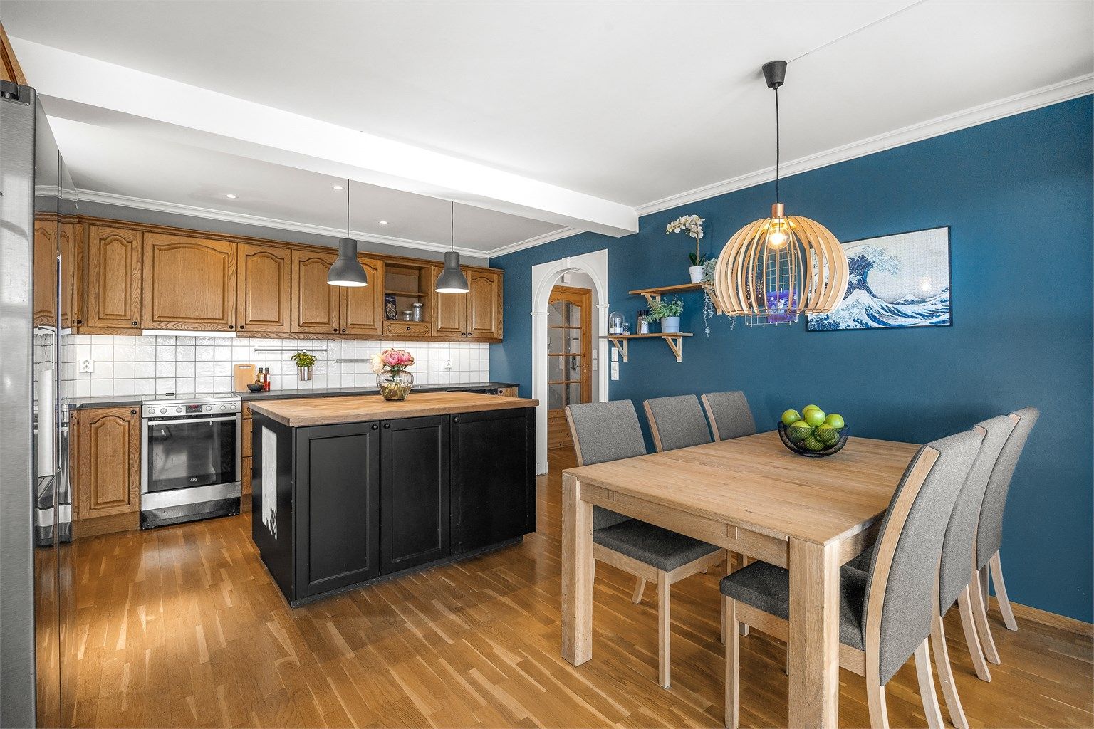 Profilert kjøkkeninnredning i seksjoner. Over- og underskap i utførelse av tre.