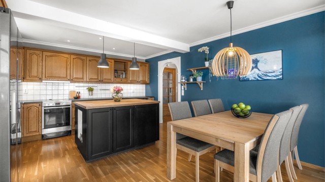 Profilert kjøkkeninnredning i seksjoner. Over- og underskap i utførelse av tre.