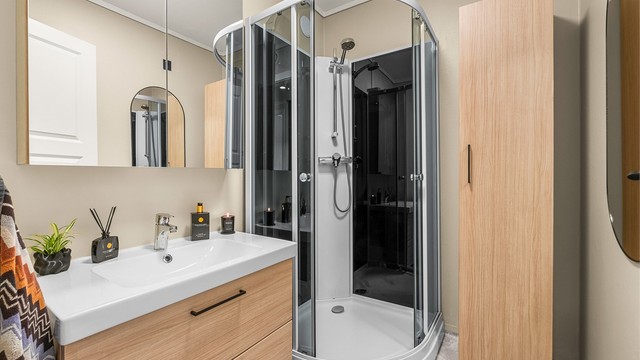 Badet måler 3 kvm og er innredet med servantskap med overskap og sideskap samt dusjkabinett.