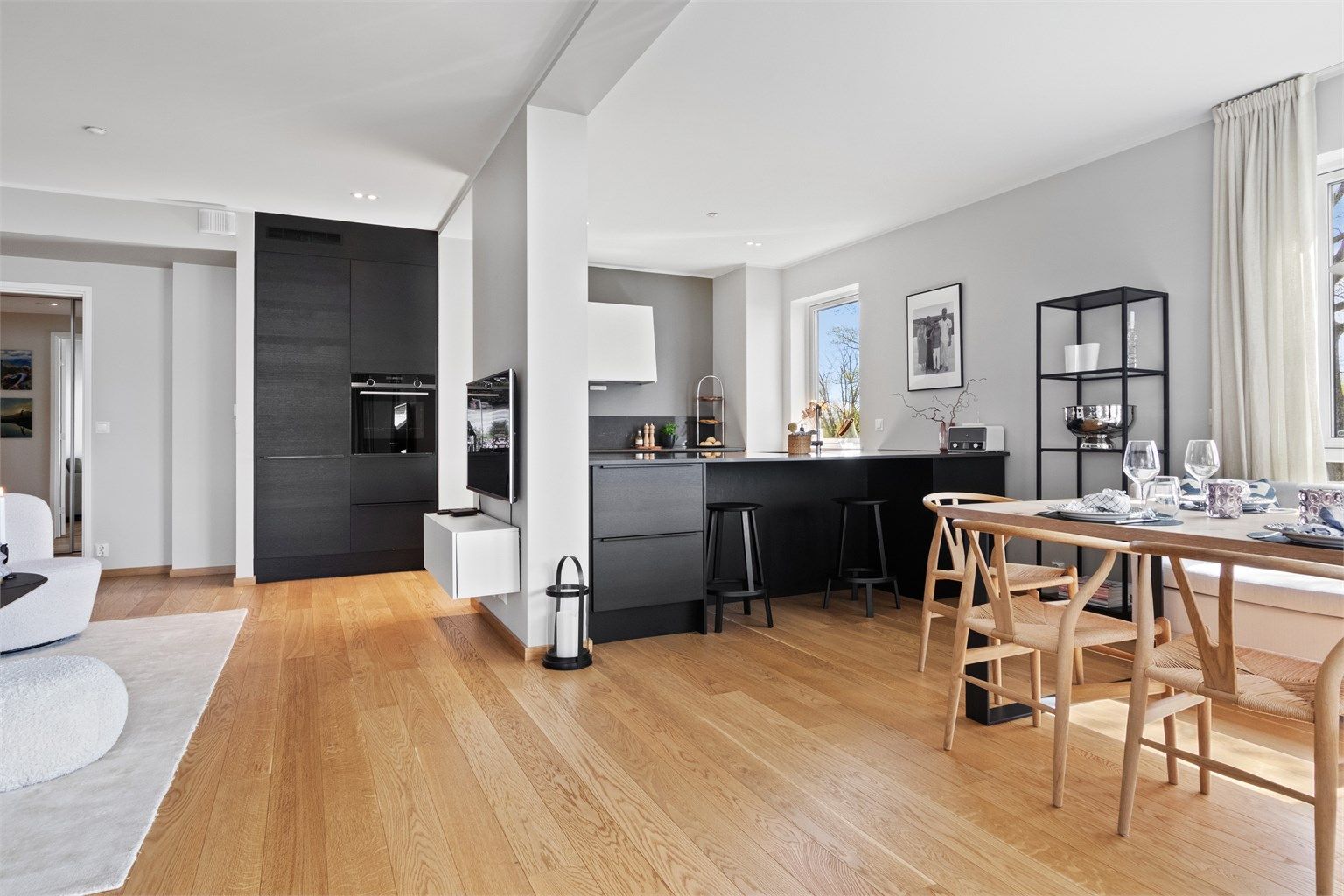 Innredningen har sorte, finerte fronter og matchende benkeplate i steinkompositt med underlimt kum i stål.