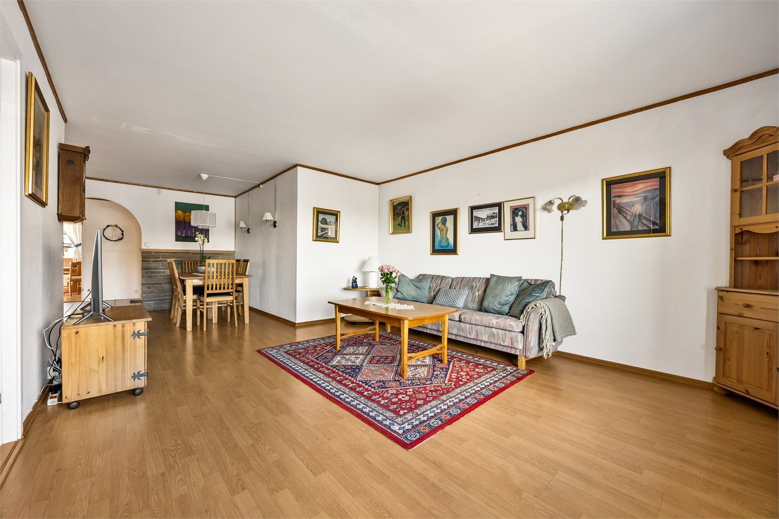 Stuen har parkett på gulvet og god plass til både sofagruppe og en egen spiseplass.