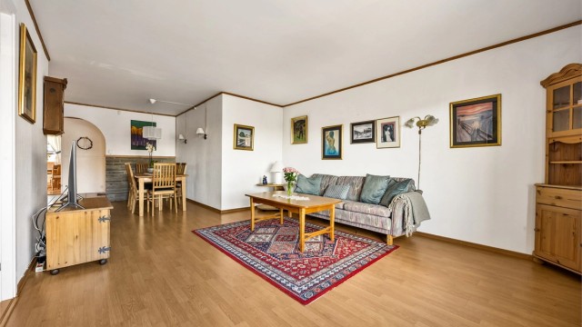 Stuen har parkett på gulvet og god plass til både sofagruppe og en egen spiseplass.