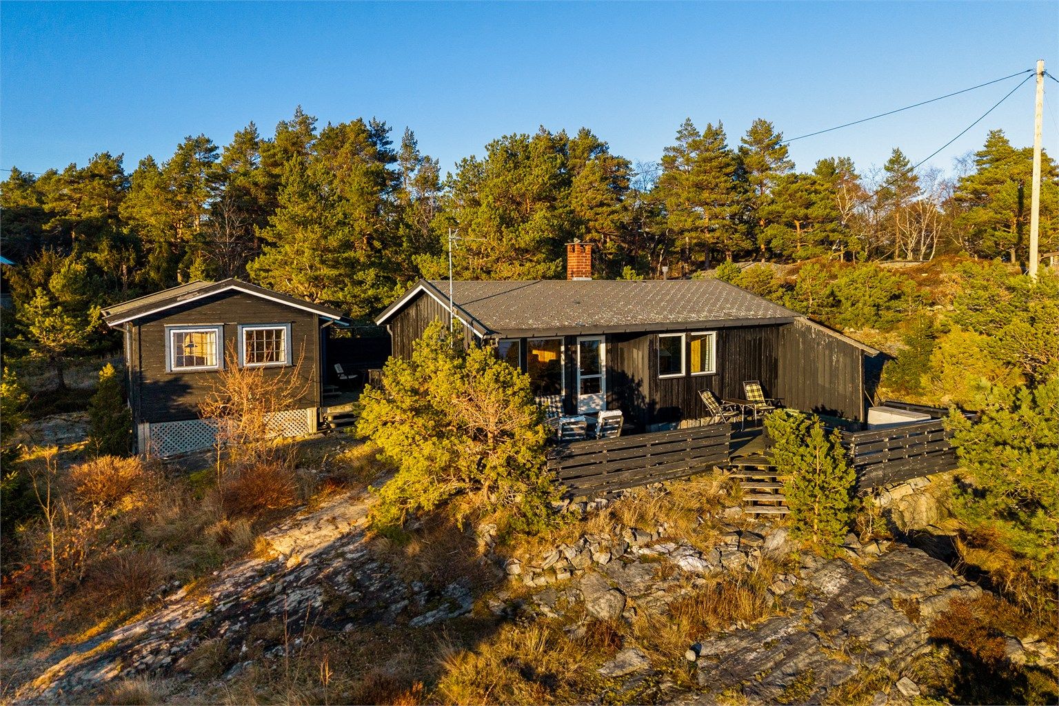 PÅ BEGGE SIDER av hytta er det terrasse.