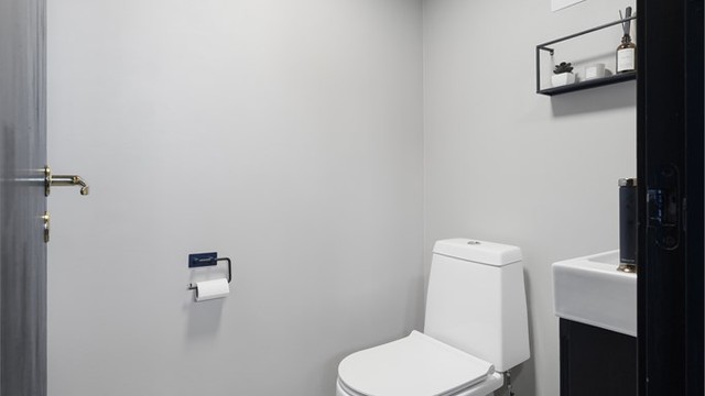 Toalettrom i underetasjen med servantinnredning og toalett.