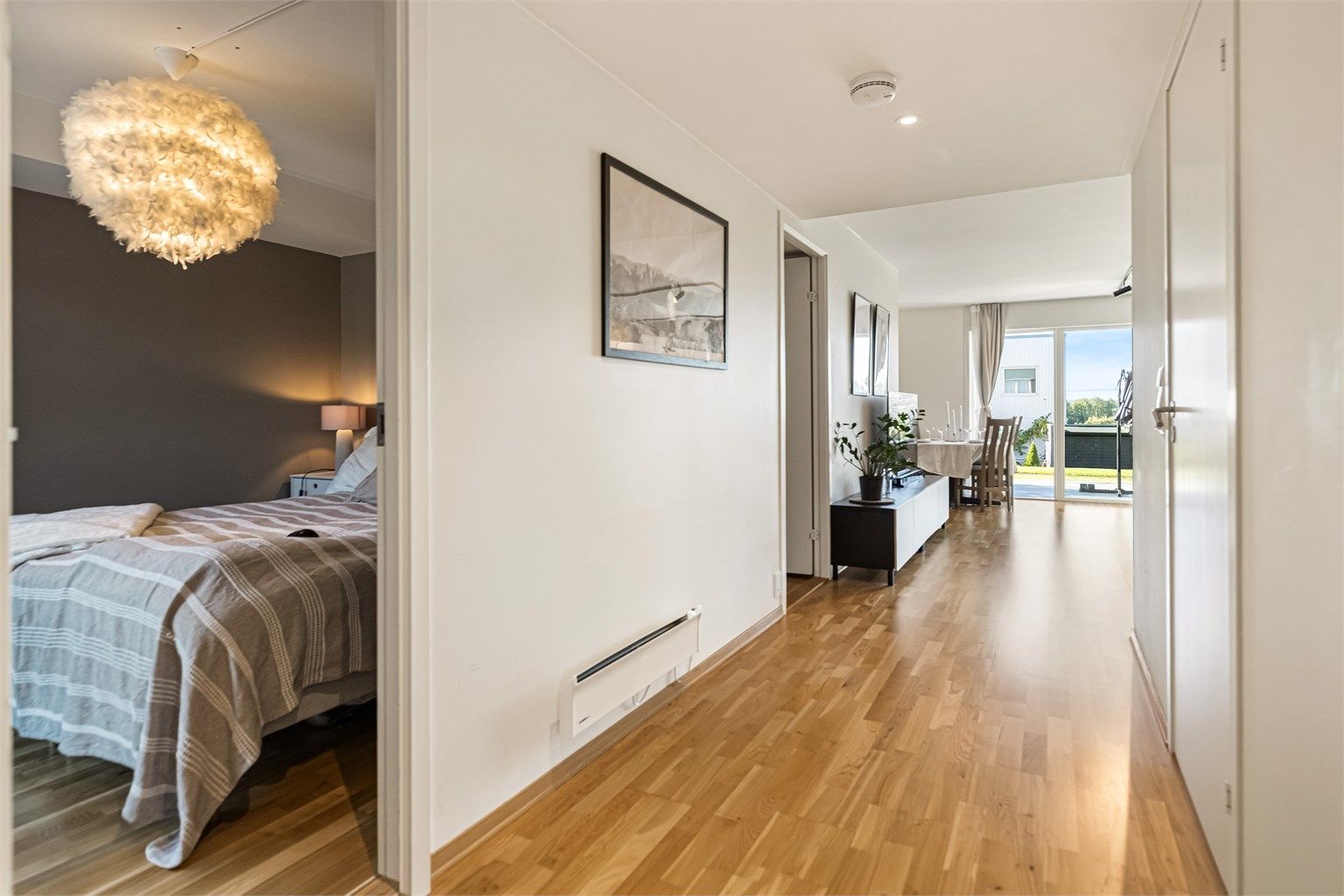 Gangen har downlights i himling og parkett på gulvet.